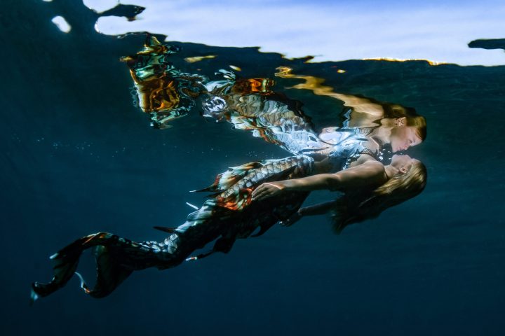 a person flying through the air while swimming in a body of water