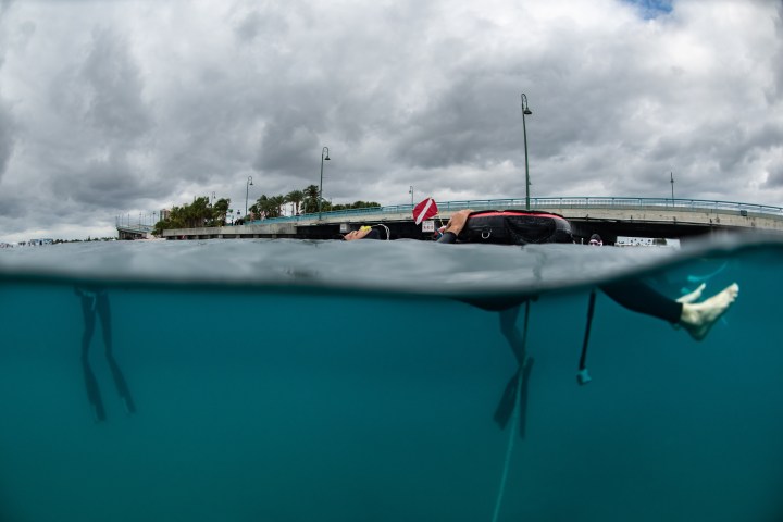 Split view of snorkeler by a bridge with cloudy sky above and water below.