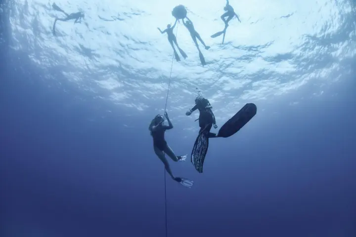 a man standing on a snow board high in the sky