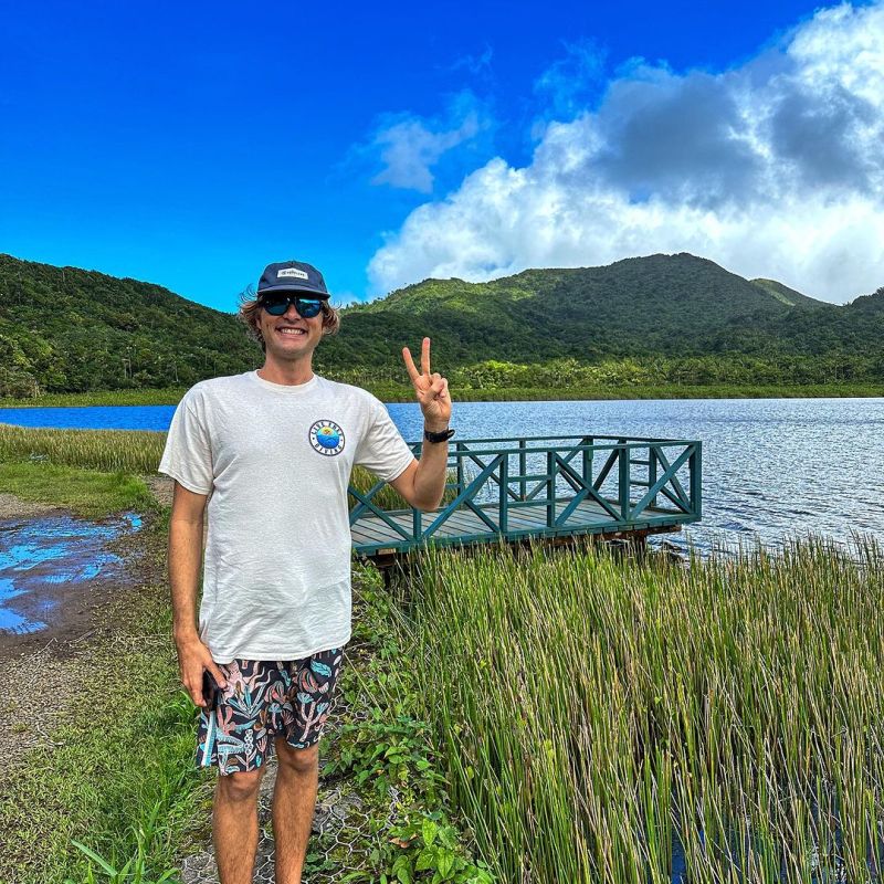 a man standing next to a body of water