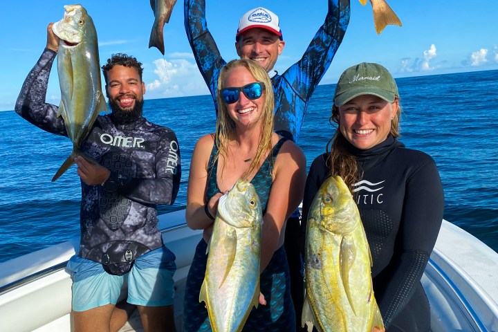 a group of people standing next to a body of water