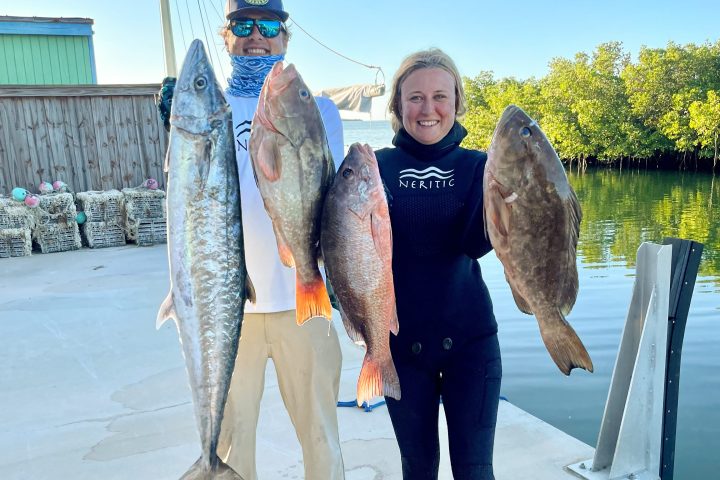 a person holding a fish posing for the camera