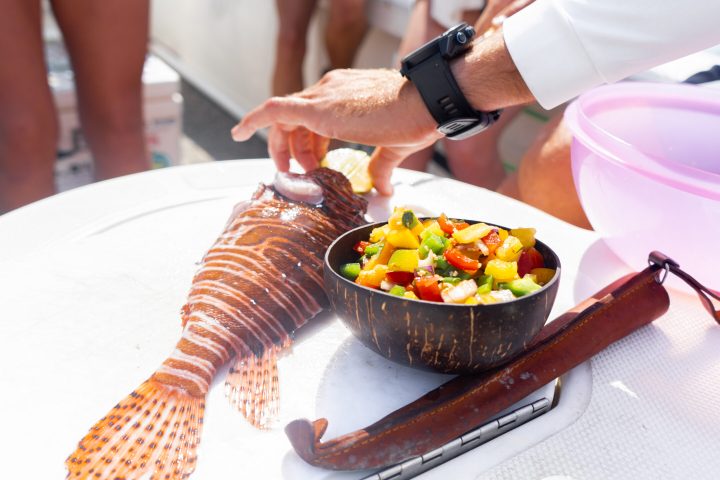 a person holding a plate of food on a table
