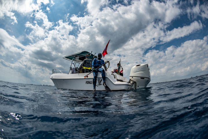 a man riding on the back of a boat in the water