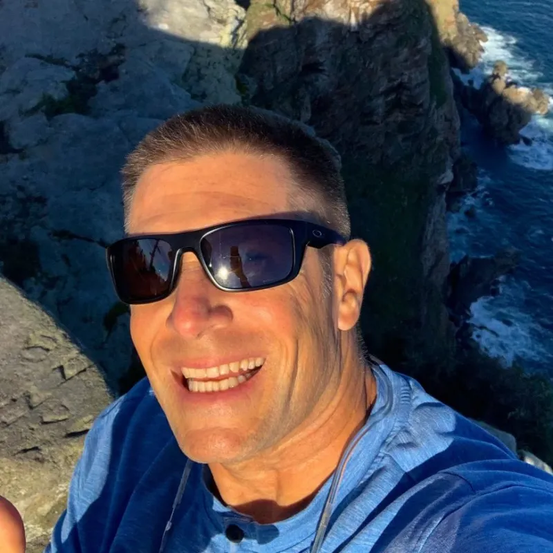 a man sitting on a rock near the ocean