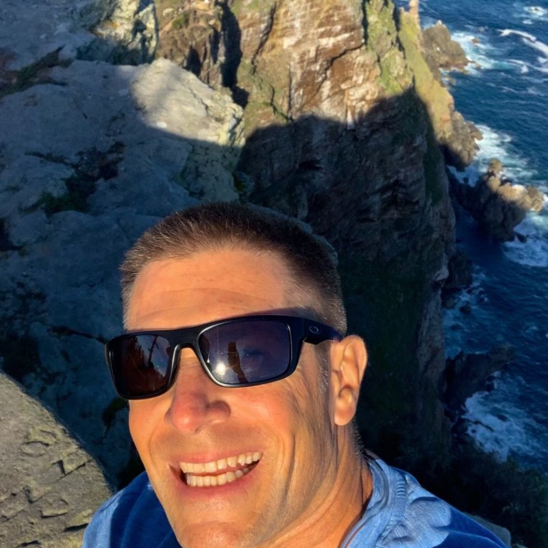 a man sitting on a rock near the ocean