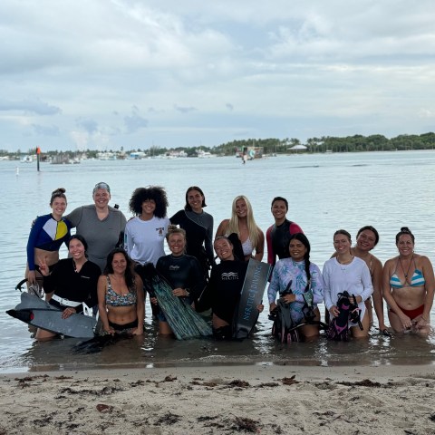 a group of people standing next to a body of water