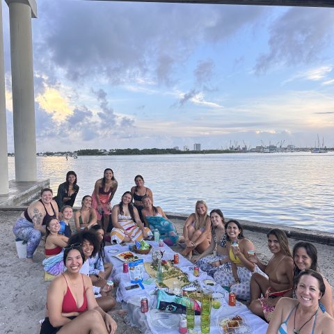 a group of people sitting next to a body of water