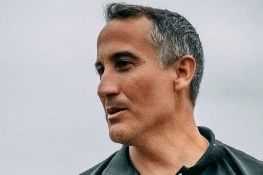 a man wearing glasses and smiling at the camera