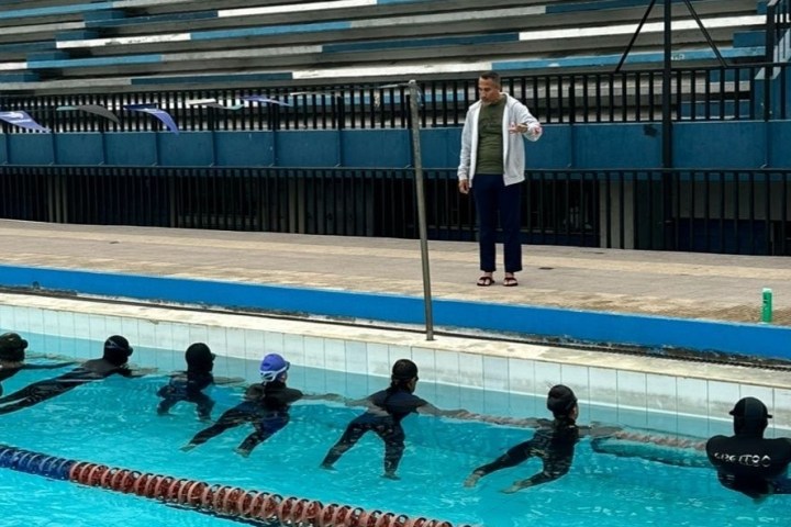 a group of people swimming in a pool of water